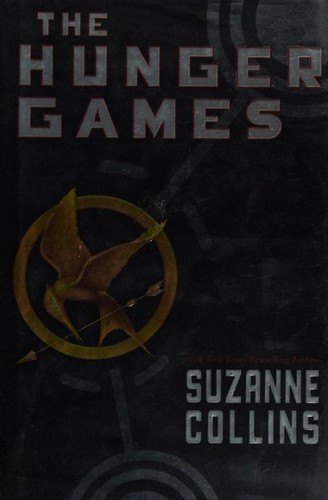 The Hunger Games book cover, a golden mockingjay pin against a black background